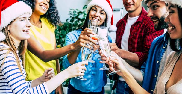 Group of happy multiracial friends celebrating together Christmas with glasses of champagne - Photo, image