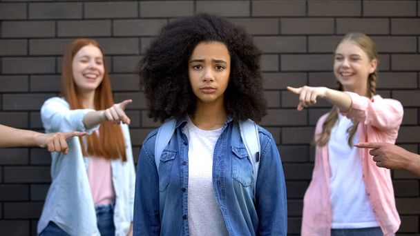 Unhappy schoolgirl looking camera, teenagers pointing fingers, bullying victim - Foto, Bild