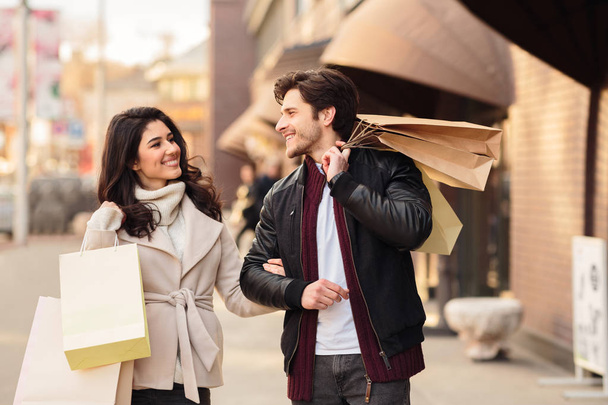 Felices adictos a las compras caminando con bolsas de compras después de hacer compras
 - Foto, Imagen