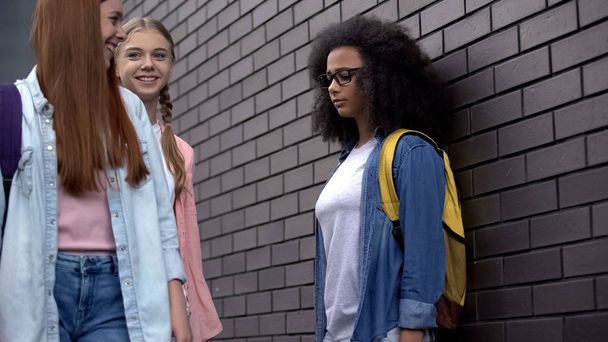 High school students mocking afro-american teenager in eyeglasses, insecurities - 写真・画像