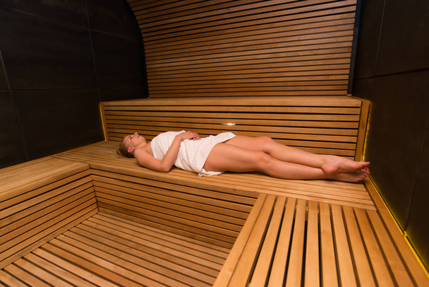 Jovem mulher bonita tendo um banho de sauna em uma sala de vapor
 - Foto, Imagem