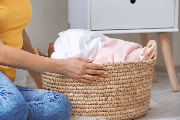Woman with laundry sitting on floor in room - Foto, Bild