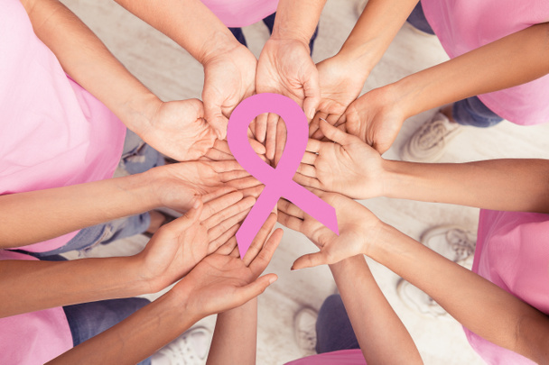 Mujer Hands Holding Cinta de cáncer de mama rosa de pie juntos
 - Foto, imagen