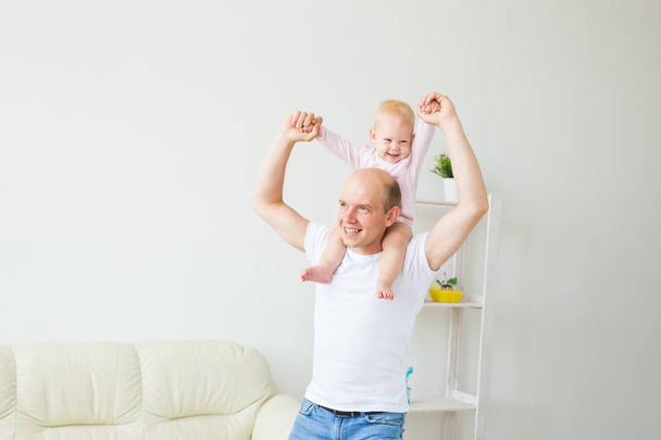 familie, ouderschap en vaderschap concept-gelukkige vader spelen met kleine baby meisje thuis - Foto, afbeelding