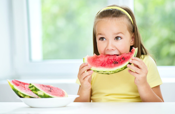 Cute little girl is eating watermelon - Fotó, kép