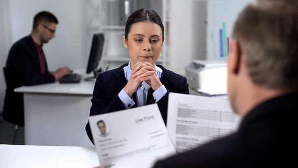 Female job candidate nervously waiting HR manager looking through resume, job - Foto, Bild
