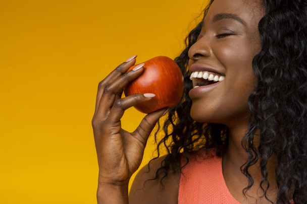 彼女のリンゴを楽しんでいる若い女性のクローズアップ肖像画 - 写真・画像