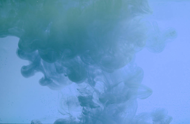 水の色のドロップ、動きで撮影した。インクが渦巻く青い背景に水の下で絹のようなインクの雲。水の中のカラフルなインク、インクドロップ. - 写真・画像