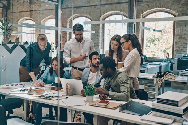 Группа молодых бизнесменов, использующих современные технологии во время работы в офисе
       - Фото, изображение