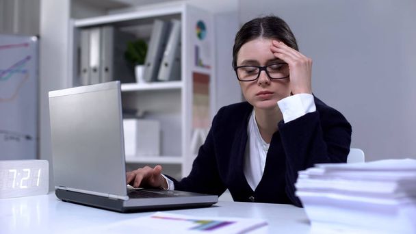 Businesswoman typing on laptop and suffering headache as result of workload - Photo, Image