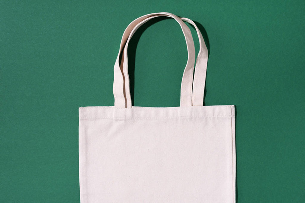 Reusable textile bag on green background. Zero waste concept with copy space. Zero waste, plastic free concept. Top view. Eco friendly mesh shopper. - Zdjęcie, obraz