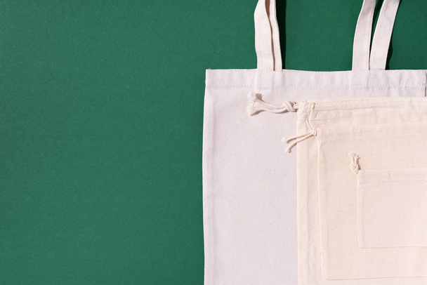 Canvas tote bag canvas and linen fabric bags with drawstring on green background with copy space. Top view. Zero waste, plastic free concept. Eco friendly shopper. - Photo, Image