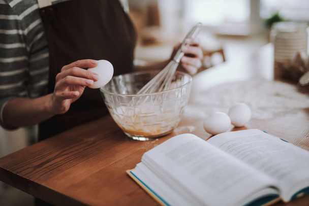 Woman is whisking eggs on kitchen at home - Valokuva, kuva