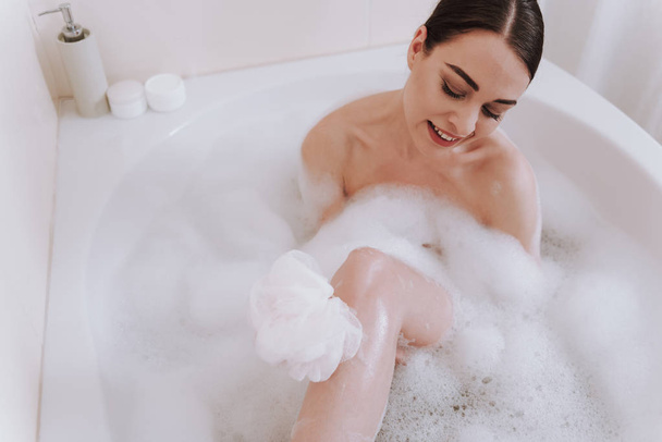 Smiling young woman enjoying taking bath at home - Foto, immagini
