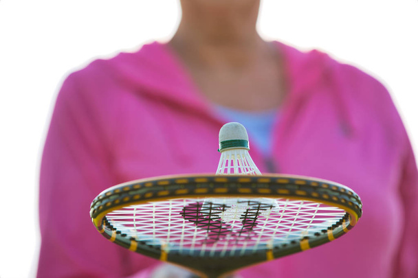 Midsection of senior woman with shuttlecock on tennis bat in park - Foto, Bild