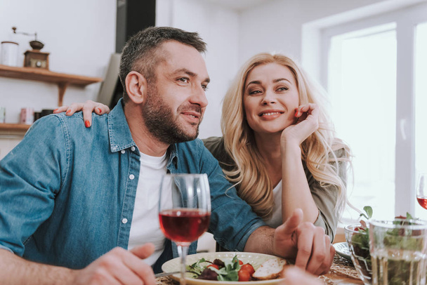 Beautiful blond woman enjoying dinner with her husband at home - Photo, Image