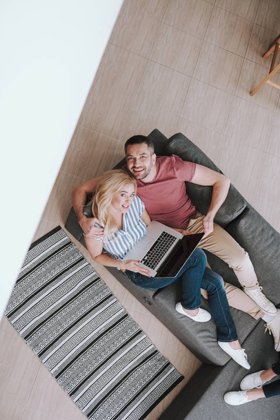 Bella coppia che utilizza il computer portatile mentre riposano insieme a casa
 - Foto, immagini