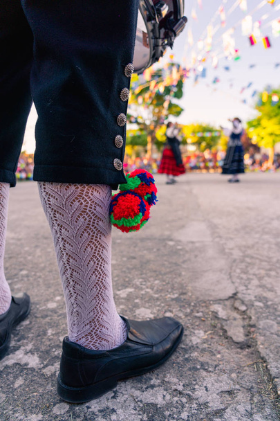 A helyi jelmez tipikus nadrágjának részletei. A háttérben táncoló személy, Segovia tradicionális tánca. - Fotó, kép