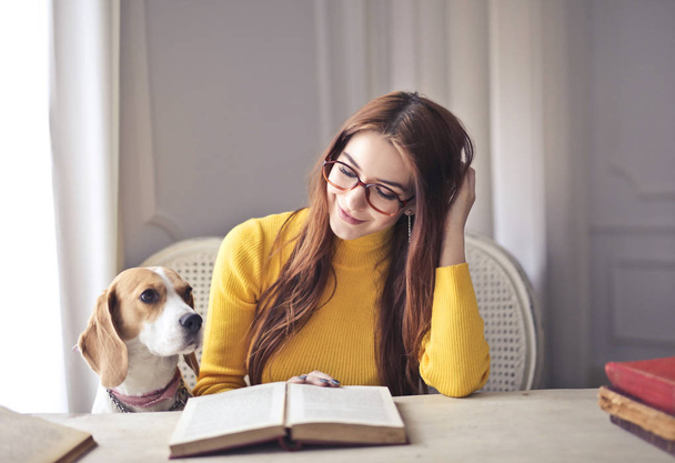 A girl studies with her dog - Φωτογραφία, εικόνα