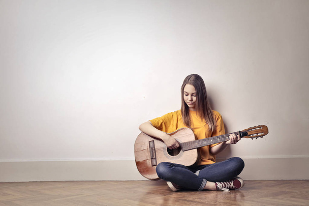 Girl play guitar on the wall - Photo, Image