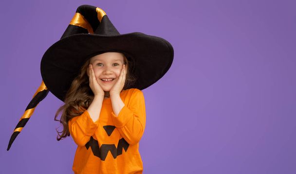 little witch on purple background - Foto, afbeelding