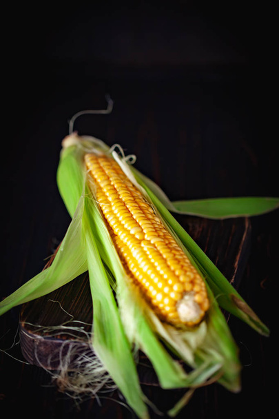 Fresh corn on cobs on rustic wooden table, closeup. Harvest Festival. Autumn background. Selective focus. Horizontal. Top view. - Фото, зображення