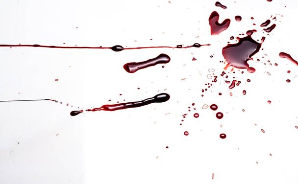 Bloed op een witte achtergrond. Druppels en spatten van bloed op een witte achtergrond. - Foto, afbeelding
