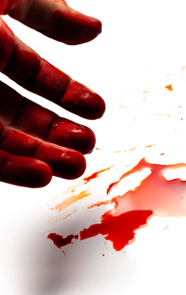 Sıçramaları ve kan damlaları ile beyaz bir arka plan üzerinde erkek kanlı el. - Fotoğraf, Görsel
