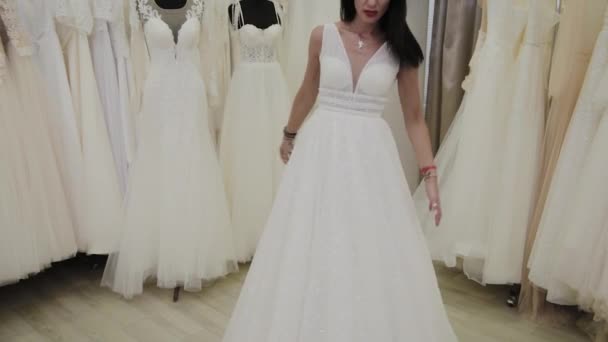schöne Mädchen misst ein Hochzeitskleid in einem Brautsalon. - Filmmaterial, Video