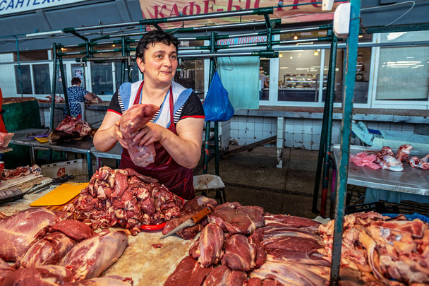 14/06/2019 Kyiv, Ukraine, pavilion of the covered farmers market with a large number of shopping arcades and a welcoming seller of fresh meat. market of Soviet Union times - Foto, imagen