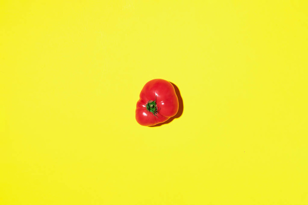 Red tomato on yellow background with copy space. Top view. Flat lay. Summer minimal concept. Vegan and vegetarian diet - Fotografie, Obrázek