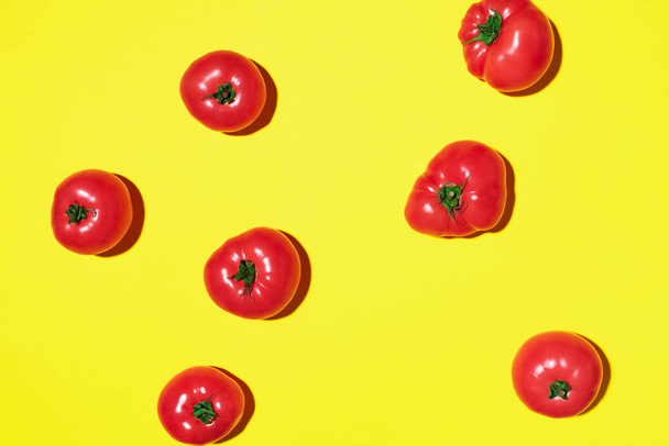 Red tomatoes pattern on yellow background. Flat lay, top view. Summer minimal concept. Vegan and vegetarian diet - Foto, Imagen