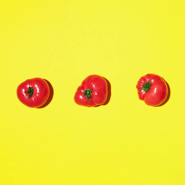 Red tomatoes pattern on yellow background. Flat lay, top view. Summer minimal concept. Vegan and vegetarian diet - Fotoğraf, Görsel
