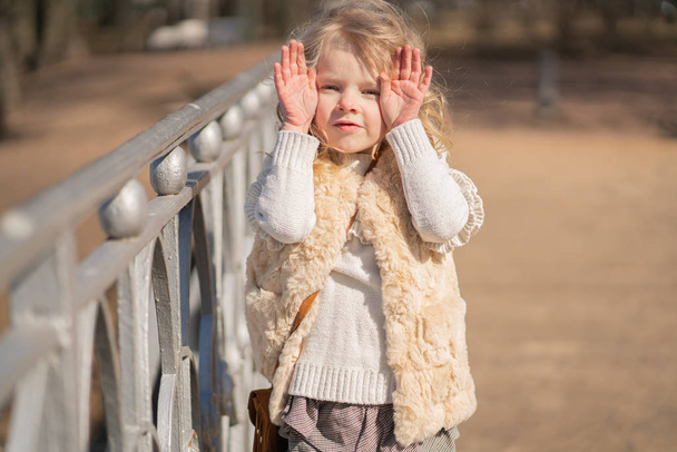 girl closing face with her hands and happy plays outdoor - Photo, Image