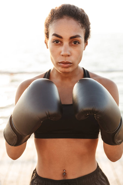 Portrait of fitness pretty woman training in boxing gloves by se - Фото, изображение