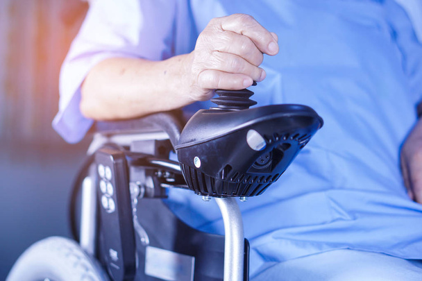 アジア高齢者、高齢者看護病棟でリモコン付き電動車椅子の老婦人女性患者: 健康の強い医療コンセプト - 写真・画像
