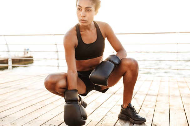 Portrait of slim pretty woman training in boxing gloves by seasi - Fotó, kép