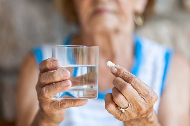 Senior woman taking her daily medication - Фото, зображення