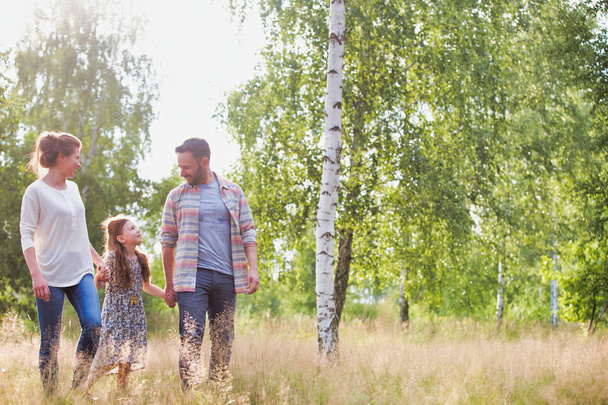 glückliche Familie, die auf einem Feld auf einem Ackerland spaziert - Foto, Bild