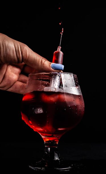Bloedige alcoholische cocktail met een spuit. - Foto, afbeelding