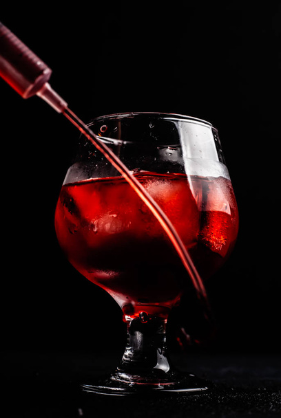 Bloody alcoholic cocktail with a syringe. - Zdjęcie, obraz