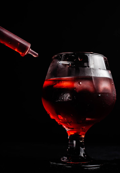 Blutiger alkoholischer Cocktail mit Spritze. - Foto, Bild