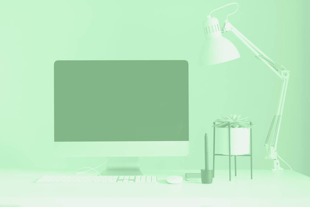 Witte bureau tafel met computer toetsenbord, muis, monitor, grafische tablet, smartphone, sappige plant en andere kantoorbenodigdheden in trendy muntkleur. Bovenaanzicht, kopieerruimte, flat lay. - Foto, afbeelding