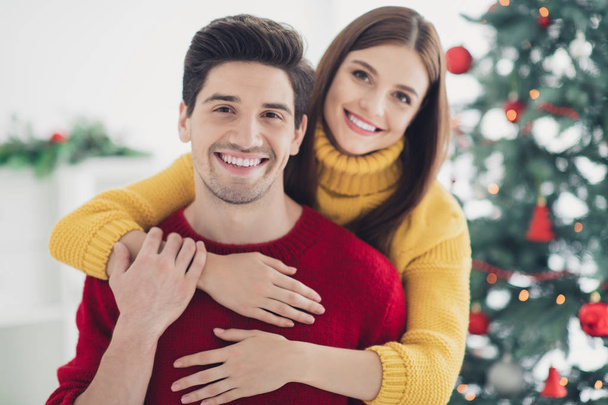 Close up photo of two spouses people have romance enjoy christmas vacation newyear party hug piggyback in house with xmas ornament indoors - Photo, Image