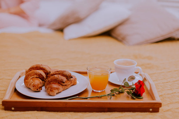 Śniadanie w łóżku, sok pomarańczowy i rogaliki z filiżanką kawy - Zdjęcie, obraz