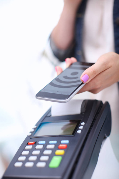 Customer is paying with smartphone in shop using NFC technology. NFC technology. Customer is paying - Φωτογραφία, εικόνα