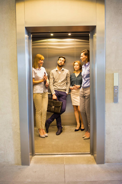 Group of businessmen and woman waiting for elevator in office - Valokuva, kuva