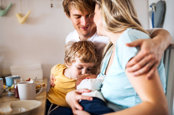 Young parents with newborn baby and small toddler son at home. - Foto, Bild