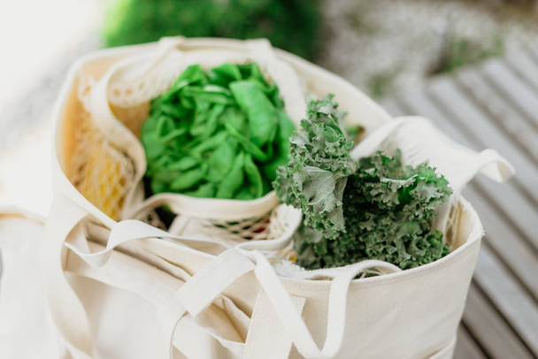 Környezetbarát hálós zsák organikus zöld zöldségekkel. Lapos fekvés, csúcskilátás. Zéró hulladék, műanyagmentes koncepció. Egészséges, tiszta táplálkozás és méregtelenítés. - Fotó, kép