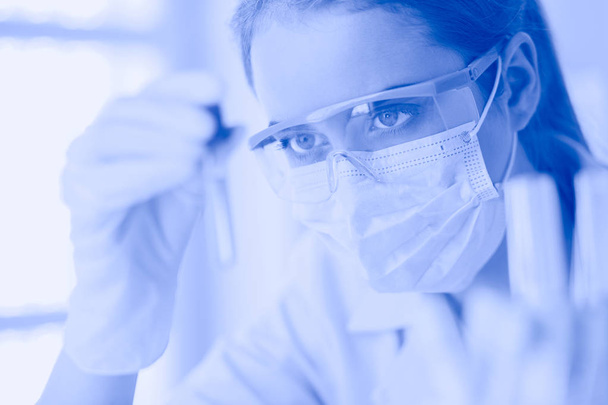 Исследователь, врач, ученый или лаборант, работающий с пластиковыми медицинскими трубками в современной лаборатории или больнице - Фото, изображение